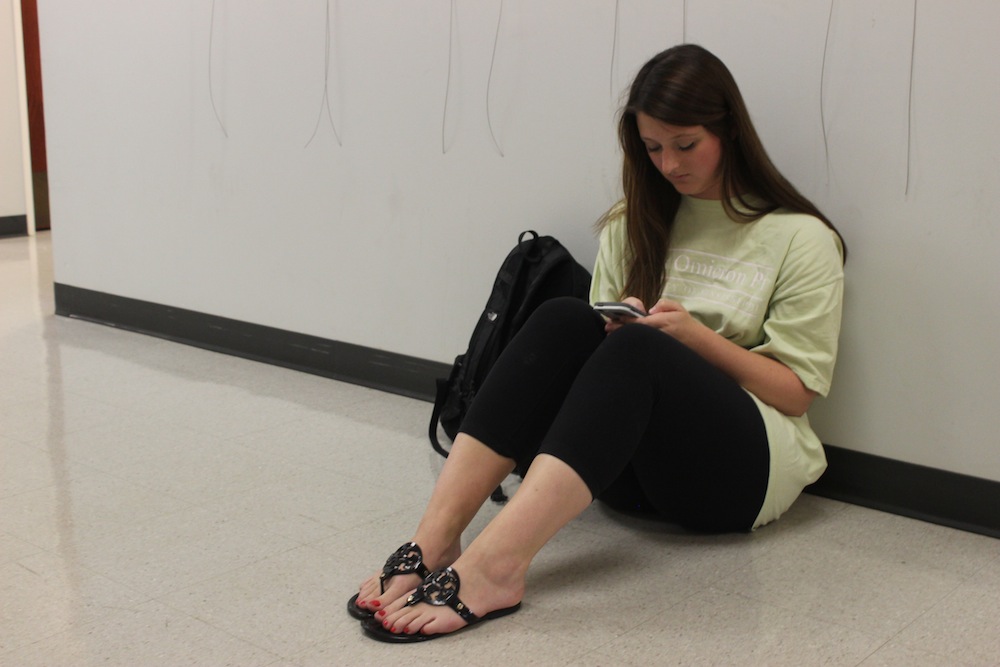 Emily Marshall is a senior studying Integrated Marketing Communications. Marshall is on her phone waiting outside for the other class to end.